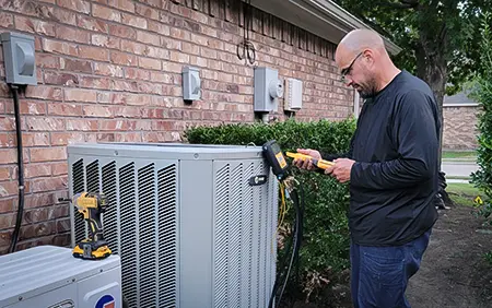 Owner of A & Z heating & Air Conditioning does a tune-up on a customer's outside unit.
